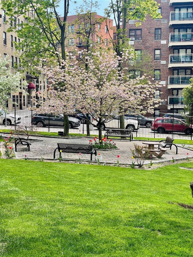 view of community with a lawn and fence