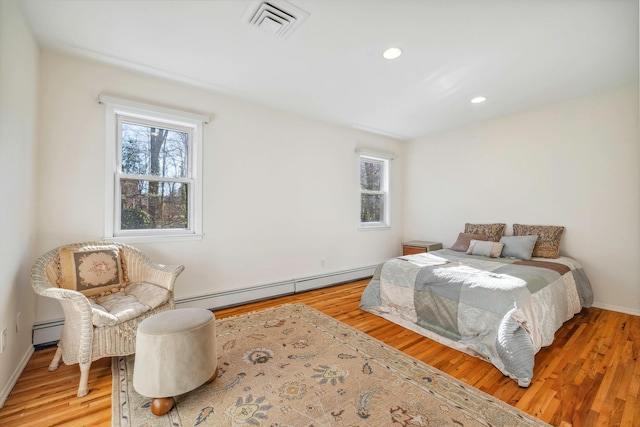 bedroom with a baseboard radiator and wood-type flooring