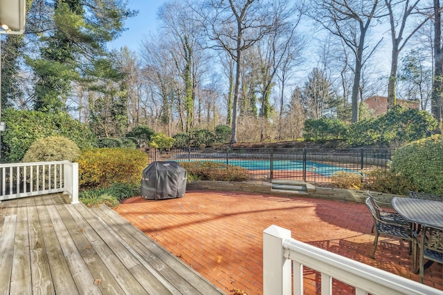 deck with a covered pool, a patio area, and a grill