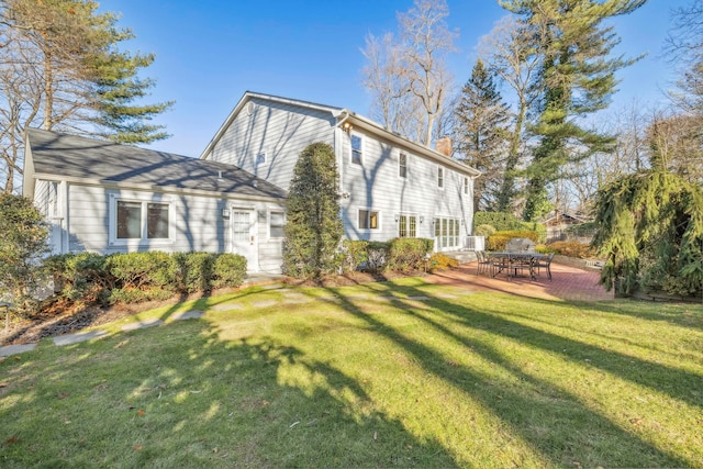 view of side of property featuring a yard and a patio