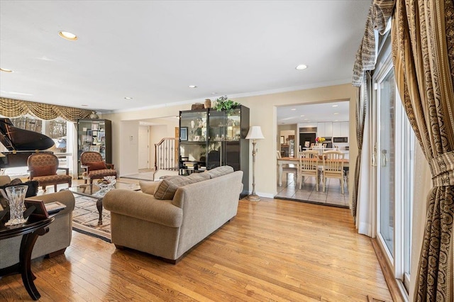 living room with crown molding and light hardwood / wood-style floors