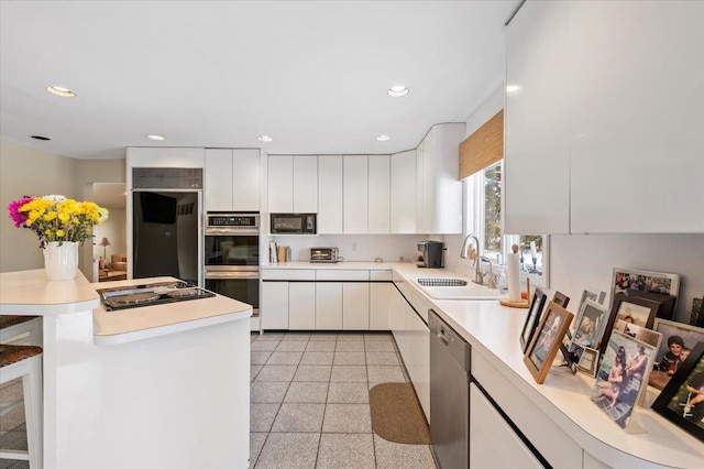 kitchen featuring sink, white cabinets, and black appliances