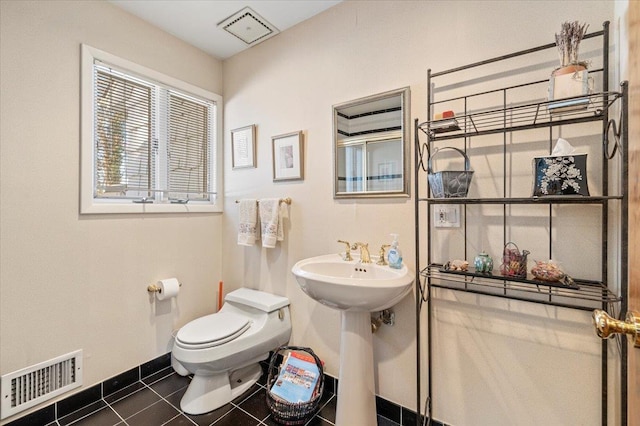 bathroom with sink, toilet, and tile patterned flooring