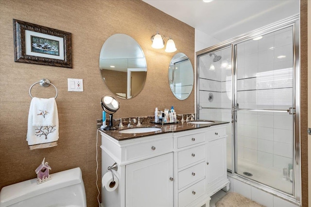 bathroom featuring vanity, toilet, and a shower with shower door