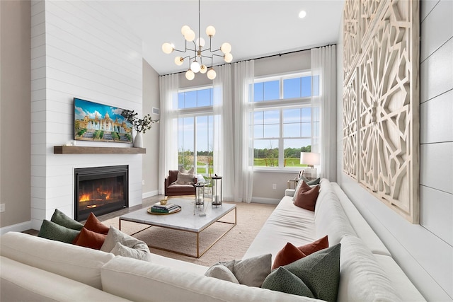 living room with carpet, a notable chandelier, and a fireplace