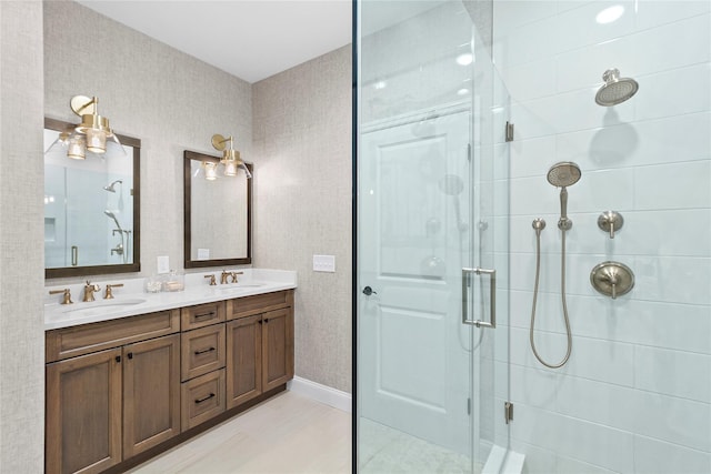 bathroom featuring a shower with shower door and vanity