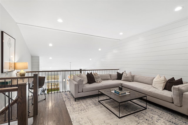 living room featuring wooden walls, light hardwood / wood-style flooring, and vaulted ceiling