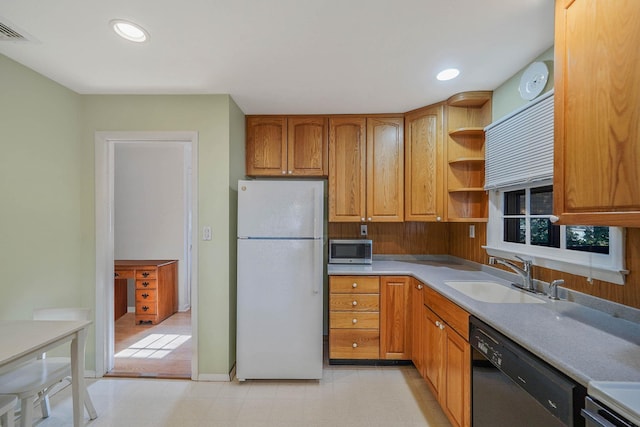 kitchen featuring dishwasher, sink, and white fridge