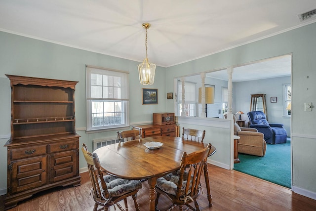 dining space with crown molding, a chandelier, and hardwood / wood-style floors