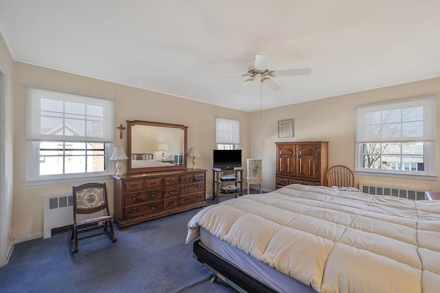 bedroom featuring multiple windows, radiator, and ceiling fan