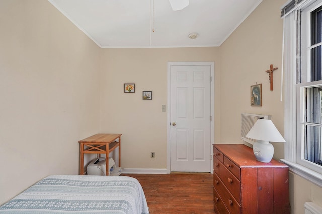 bedroom featuring crown molding, dark hardwood / wood-style floors, and ceiling fan