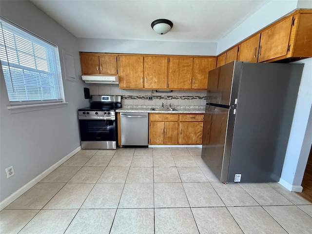 kitchen featuring sink, tasteful backsplash, light tile patterned floors, and appliances with stainless steel finishes