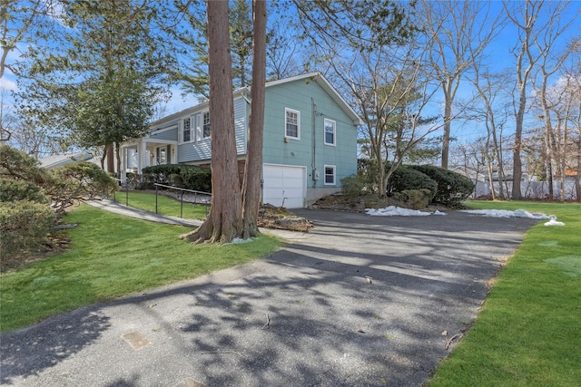 view of side of property with a garage and a lawn