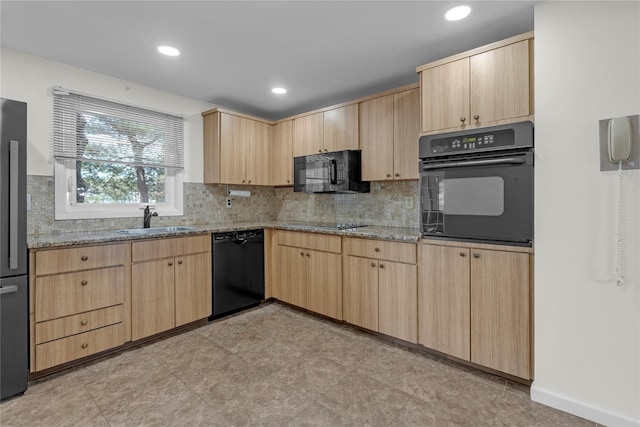 kitchen with sink, light stone counters, light brown cabinetry, and black appliances