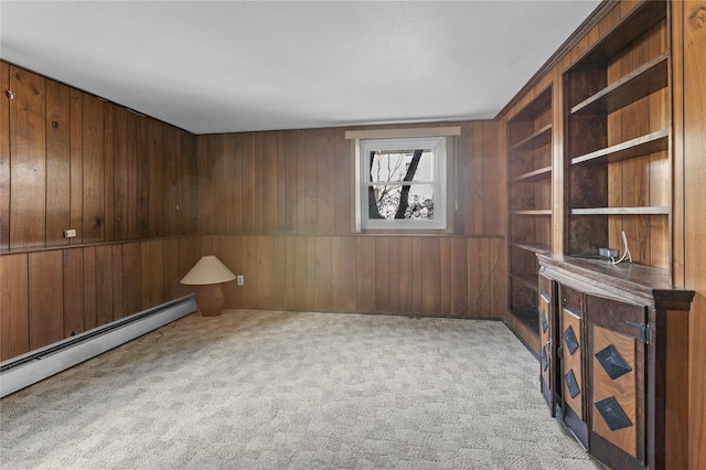 interior space with a baseboard radiator, wooden walls, and light colored carpet