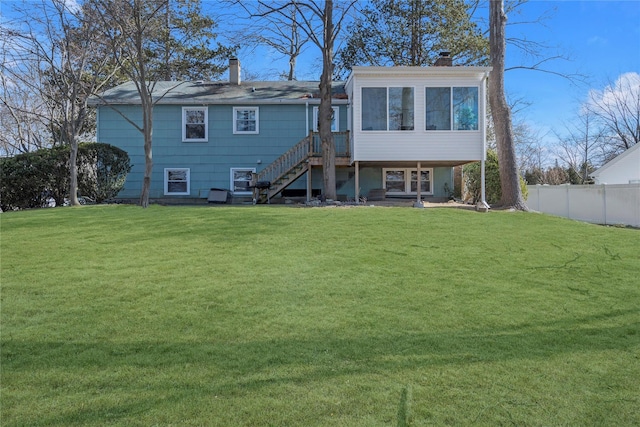 back of property with a yard and a sunroom