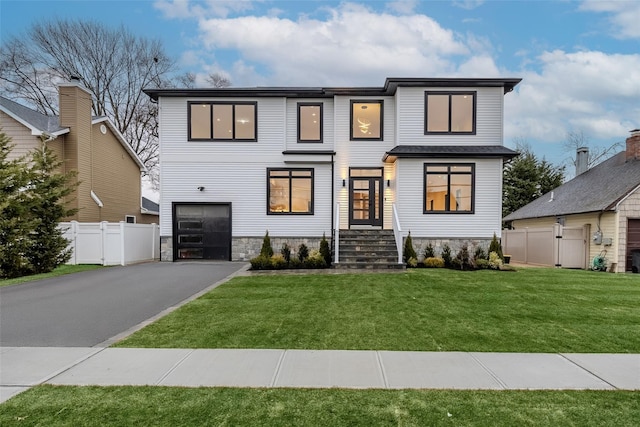 view of front of house featuring a garage and a front lawn