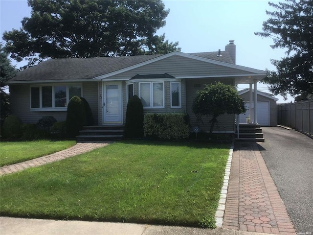 view of front of house with a garage, a front lawn, and an outdoor structure