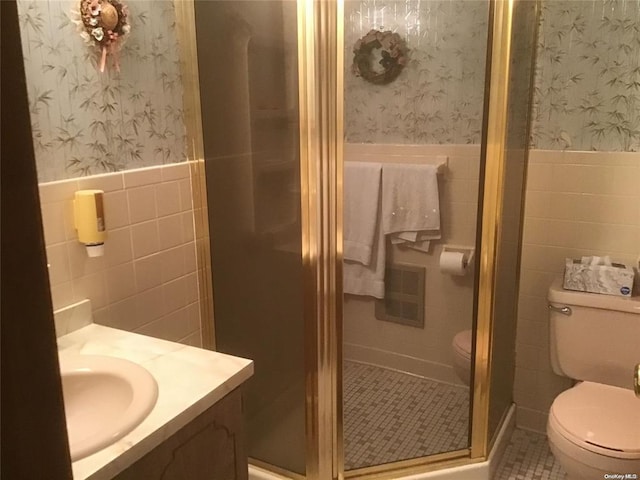 bathroom with vanity, walk in shower, tile walls, and toilet