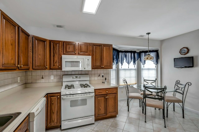 kitchen with pendant lighting, white appliances, decorative backsplash, and light tile patterned flooring