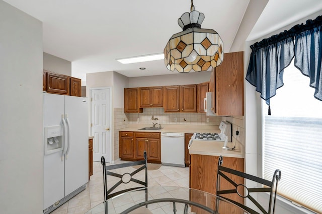 kitchen featuring sink, white appliances, light tile patterned floors, and tasteful backsplash