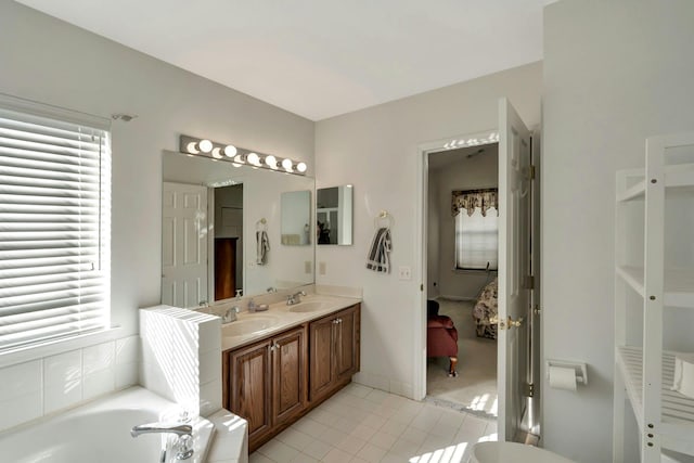 bathroom featuring tiled bath, tile patterned floors, and vanity