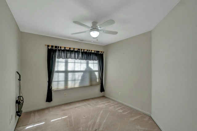 spare room with ceiling fan and light carpet