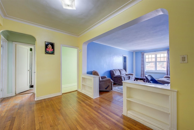 unfurnished living room featuring crown molding and hardwood / wood-style flooring