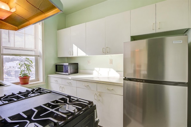 kitchen featuring stainless steel appliances and white cabinetry