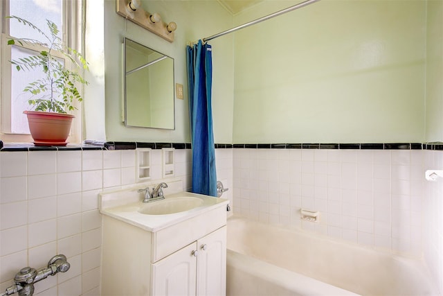 bathroom with vanity, shower / tub combo, and tile walls