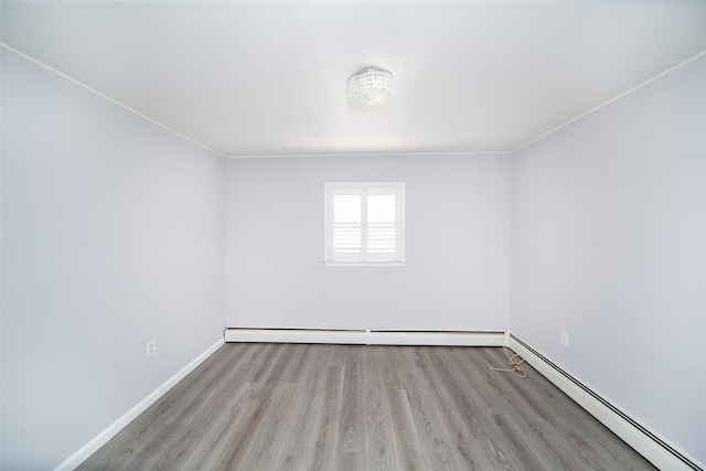 spare room with light wood-type flooring and baseboard heating