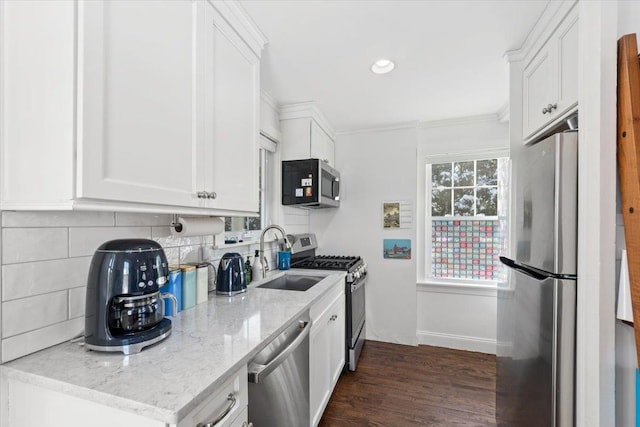 kitchen with sink, white cabinetry, light stone counters, decorative backsplash, and stainless steel appliances