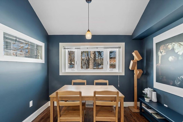 dining room featuring dark wood-type flooring and vaulted ceiling