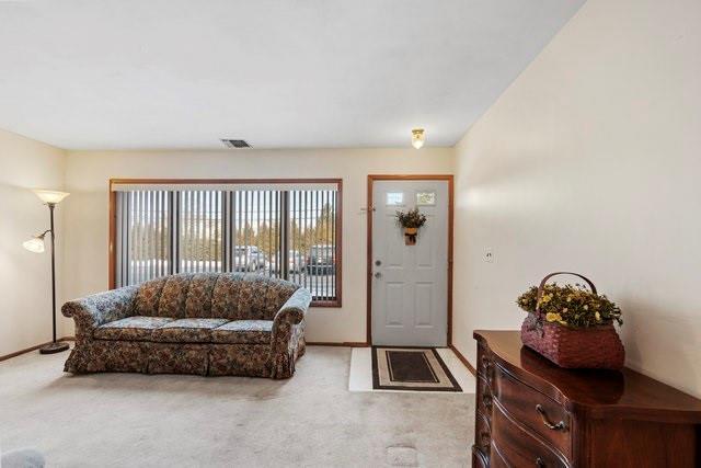 foyer featuring light carpet