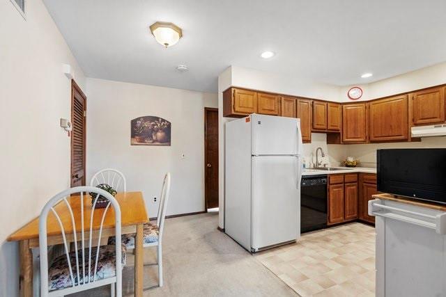 kitchen featuring dishwasher, white fridge, and sink