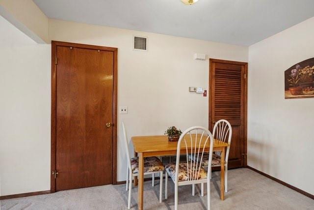 dining space with light colored carpet