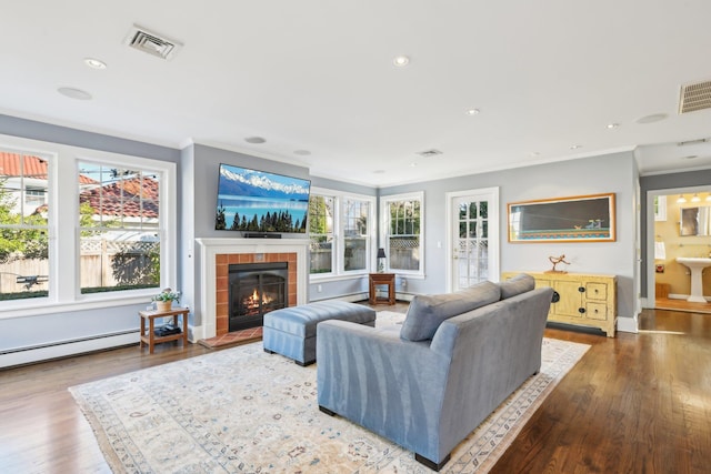 living room with a baseboard radiator, a fireplace, ornamental molding, and wood-type flooring