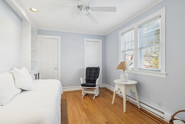 bedroom with a baseboard radiator, ornamental molding, light hardwood / wood-style floors, and ceiling fan