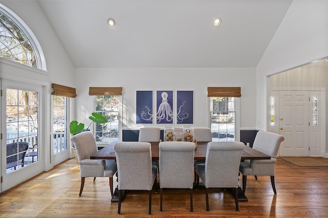 dining space featuring hardwood / wood-style flooring and high vaulted ceiling