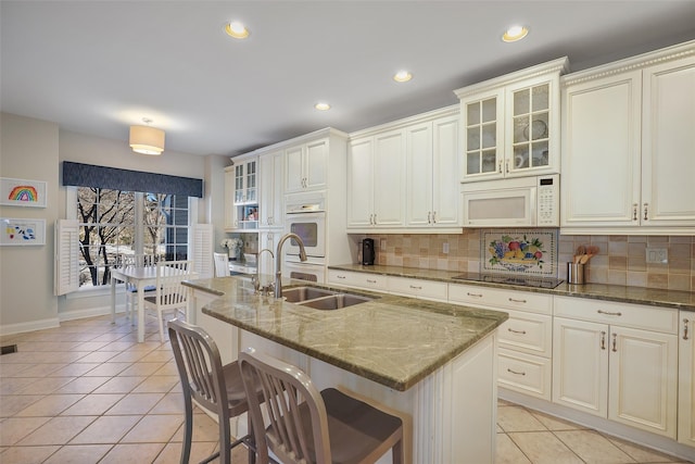 kitchen with sink, dark stone countertops, and light tile patterned floors