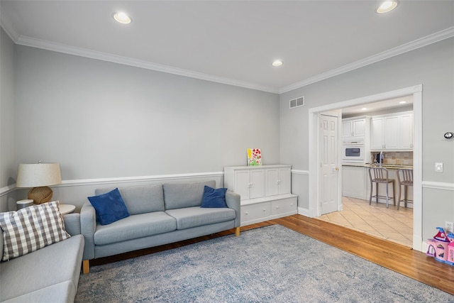 living room featuring crown molding and light wood-type flooring