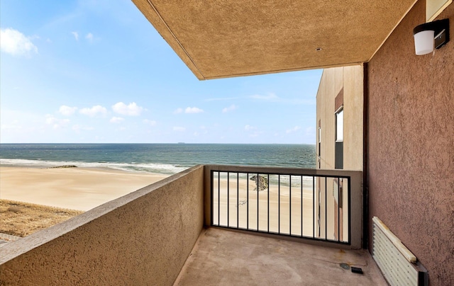 balcony featuring a water view and a view of the beach