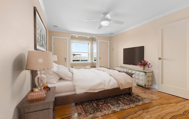 bedroom with hardwood / wood-style flooring, ornamental molding, and ceiling fan