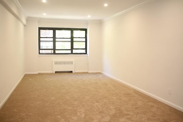 empty room with crown molding, carpet flooring, and radiator