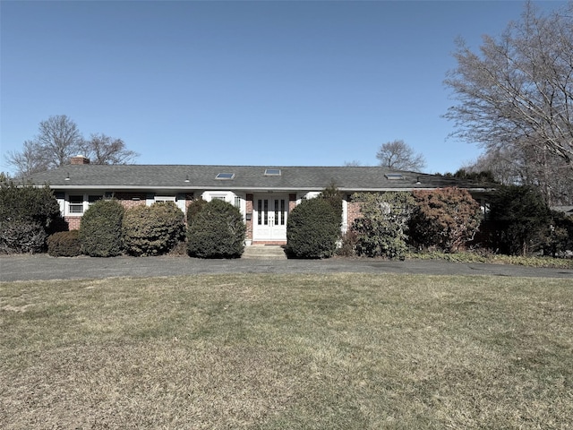 ranch-style house with brick siding, french doors, and a front yard