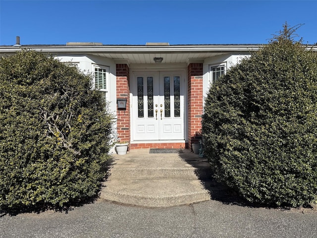 view of exterior entry with brick siding