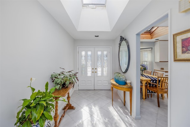 entryway with a skylight, light tile patterned floors, and visible vents