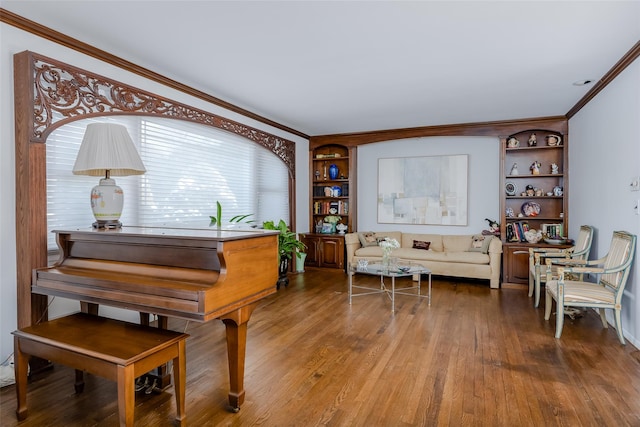 living area with built in features, crown molding, and wood finished floors