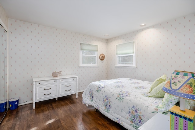 bedroom with dark wood-style flooring and wallpapered walls