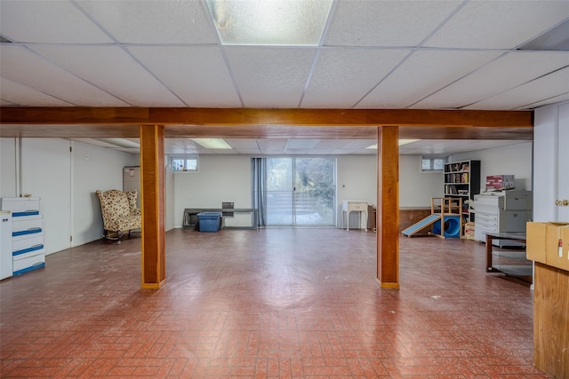 below grade area featuring brick floor and a drop ceiling